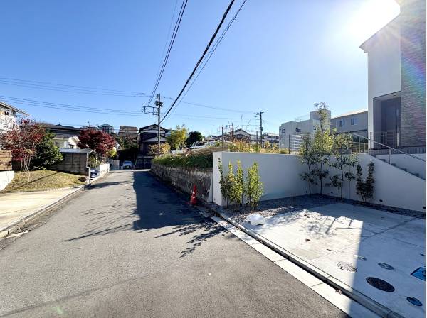 日差しに包まれた前面道路が住まいの立地の良さを静かに伝える景色