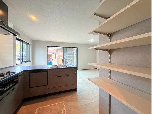 キッチンは広々としたL字型、背面には便利な造作の棚！