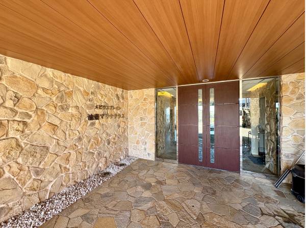石張りの質感がリゾートマンションらしい落ち着きを演出するエントランス