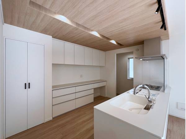 キッチン上部の板張り天井や工夫されたライティングが洗練感を演出