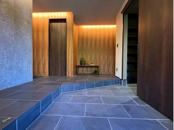 高級感溢れる間接照明やタイル調のフロアのエントランス