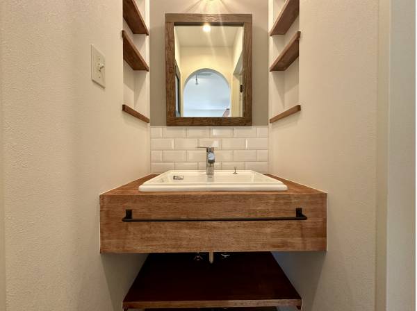 古材の木枠を使用した造作洗面台/ 大きな鏡タイル貼りの壁とマリンランプ