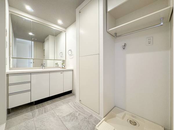 リネンスペースや棚が備わったゆとりあるパウダールーム