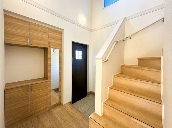 階段下に土間スペースを設けた開放的な吹抜けの玄関ホール