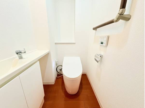 手洗いカウンターと手すり付きのタンクレストイレ。ゆとりある清潔な空間です
