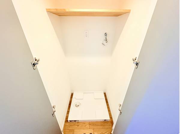 扉付きで生活感を隠せる洗濯機置き場　上部に便利な収納棚を備えています