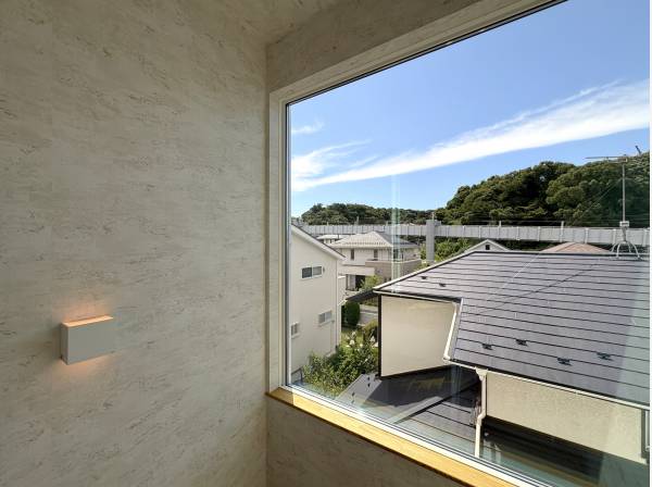 大きな窓の先にも街並みと周囲に広がる緑が