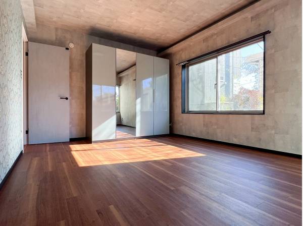 ミラー付きの収納が備わった約9帖の広々ベッドルーム