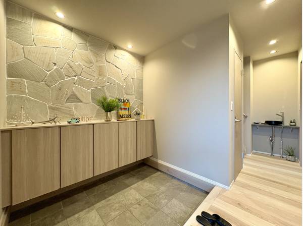 玄関もゆったりスペース。石張りが空間を引き締めます。洗面も完備