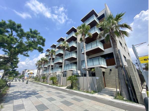 風に揺れるヤシの木がリゾートマンションのムードを演出