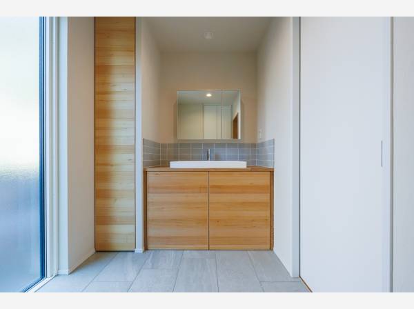 木の温もりとタイルの質感が調和する洗面空間。