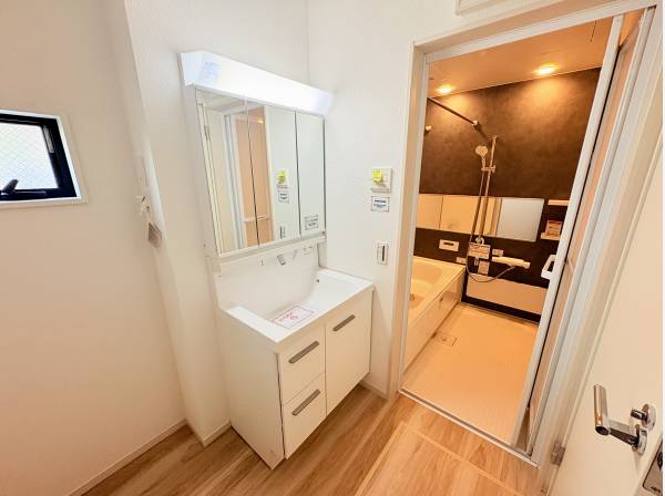 三面鏡裏にも収納できる洗面化粧台。小窓から光が入る明るく清潔な空間です