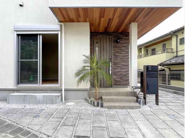 石畳風のアプローチと木目調がお洒落な玄関