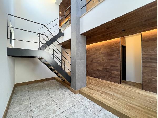 吹き抜けと印象的な鉄骨階段が出迎えるエントランスホール