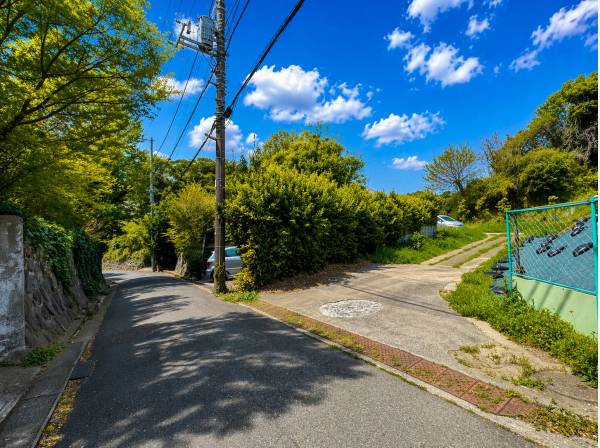 緑に抱かれた高台アプローチ、静寂へと続く私邸入口。