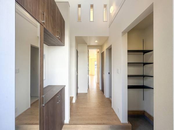 吹抜けが開放的な玄関は姿見とシューズインクロークを完備