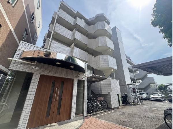 爽やかな白タイルとウッド調のエントランスドアがバランスよく調和