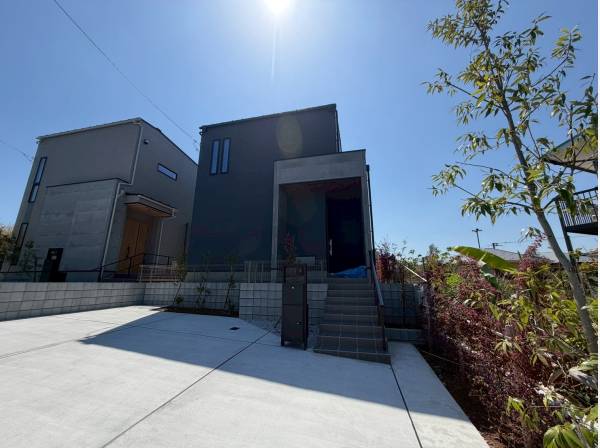 並列2台のカースペースを備えた青空の中佇む贅沢邸宅