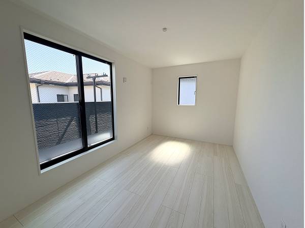 白と明るい床で統一された清潔な洋室。バルコニーへ出られる大きな窓