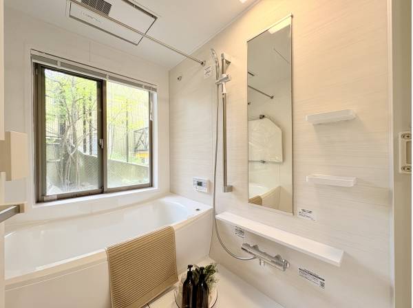 優しく照らす照明と庭を眺めれる窓が印象的なバスルーム