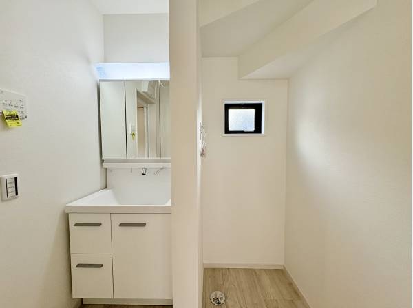 洗面所。床のフローリングとホワイトのクロスが