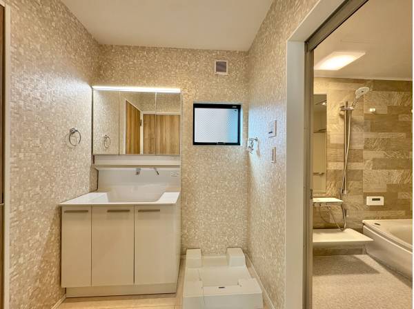 洗面室は白を基調とした清潔感のある空間。三面鏡の裏には十分な収納