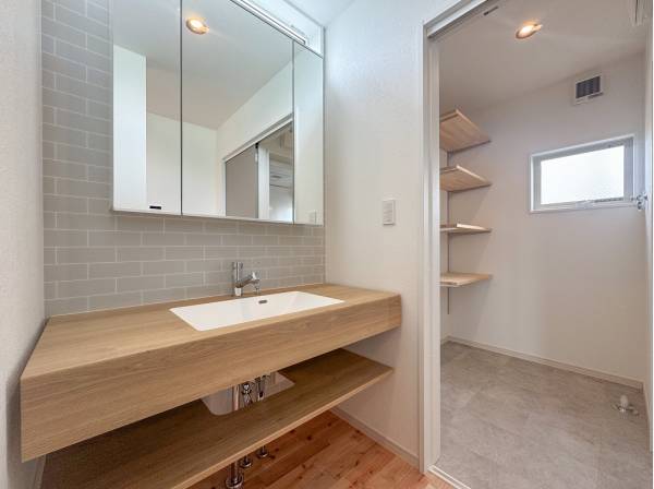 タイル張りの可愛らしい造作洗面台 ランドリールームの可動棚も嬉しい