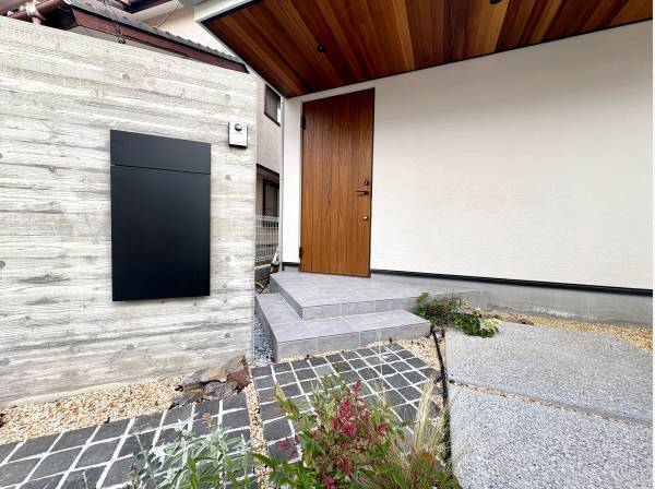 杉板の陰影と洗い出しの質感が調和する、趣あるアプローチです