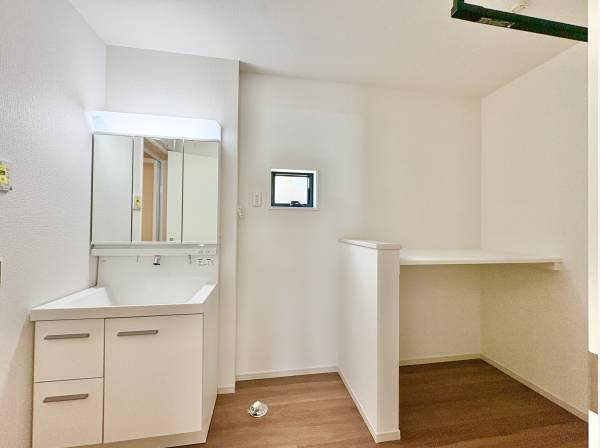 洗面室は白を基調とした清潔感のある空間。三面鏡の裏には十分な収納