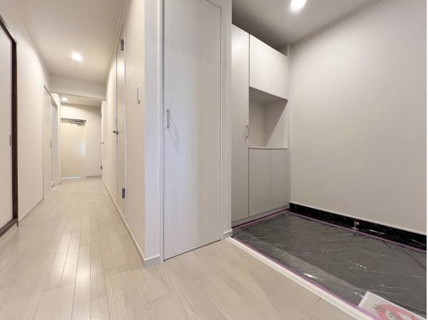 明るいトーンで統一された玄関ホールからリビングへのアプローチ