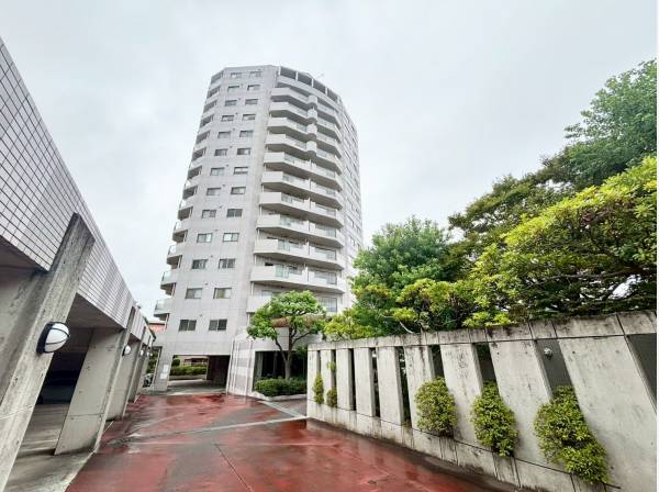 周辺の街並みに調和する、洗練されたデザインのマンション外観です。