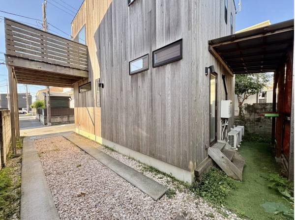 緑と木の外壁が調和する、建物脇のアプローチ