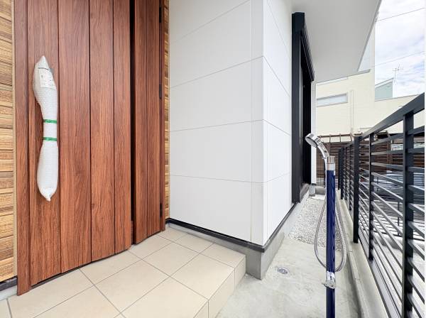 重厚感のある玄関扉、手前には混合水栓の外シャワー完備