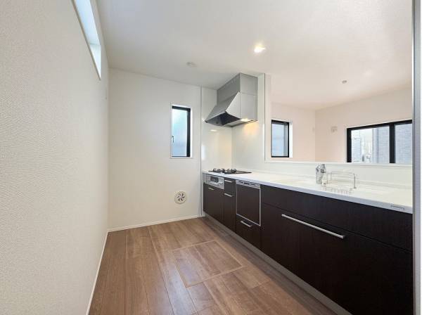 背面の高窓から木漏れ日が注ぐ明るいキッチン