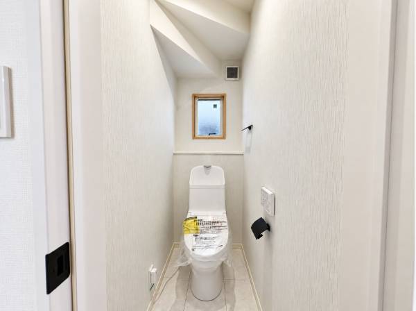 小窓から光を取り込む、白を基調とした清潔感と落ち着きのあるトイレです。