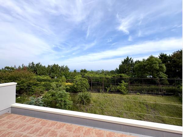 リビングの先に広がるバルコニーから、松林越しの穏やかな景色を望みます。