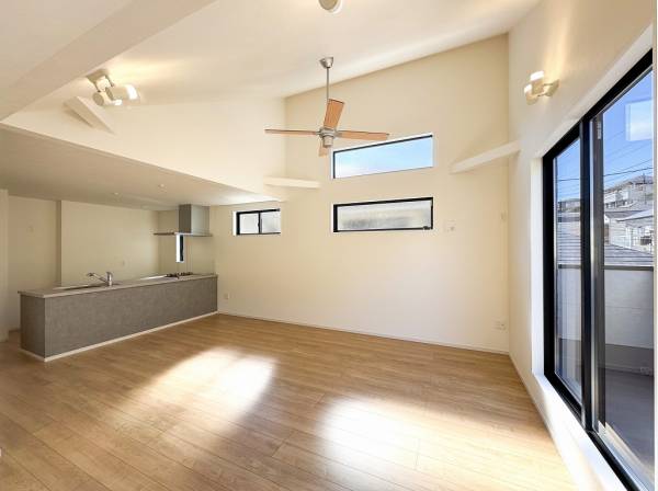 勾配天井の明るいリビングにはシーリングファンが付いています