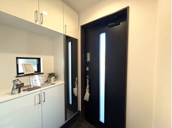 全身鏡とたっぷり収納を備えた玄関。カウンターは飾り棚としても便利