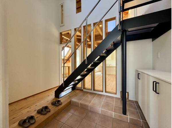 吹き抜けの玄関が迎える、開放感とデザイン性のある入口。