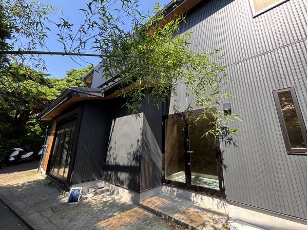 スタイリッシュな黒を基調とした家。目の前に広がる緑が涼しげ