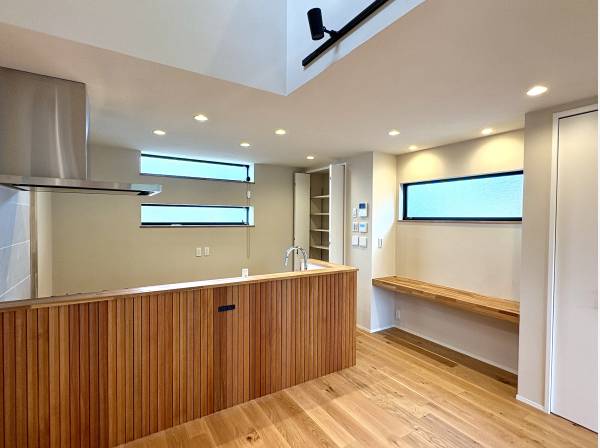 キッチンの裏には無垢の羽目板をあしらい、素材の温もりが空間を包みます