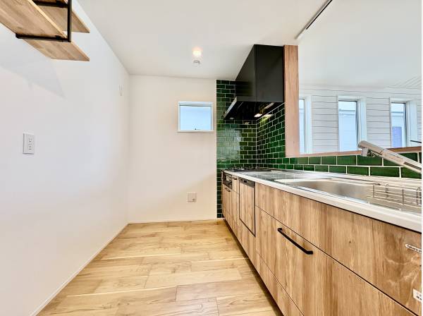 キッチンは木目調でグリーンのタイルが印象的です。