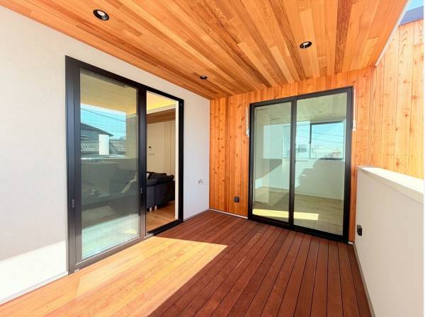 リビングと居室それぞれからフラットに繋がる天然木のバルコニー