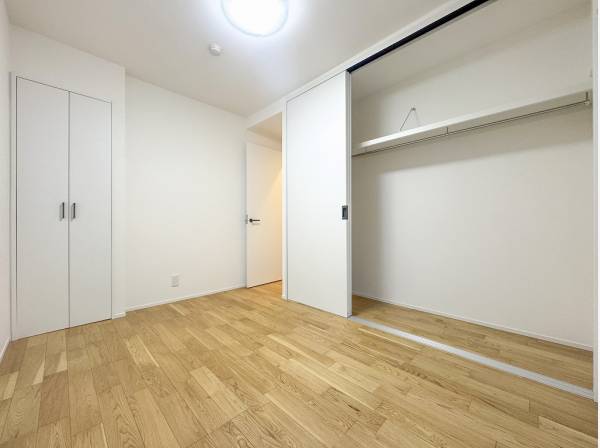 バルコニーから自然光が注ぐベッドルームは収納も充実