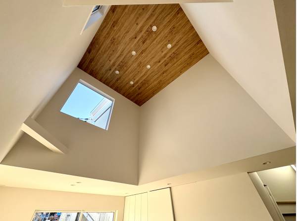 リビング上部の吹き抜け天井は木目調で落ち着きある空間です。