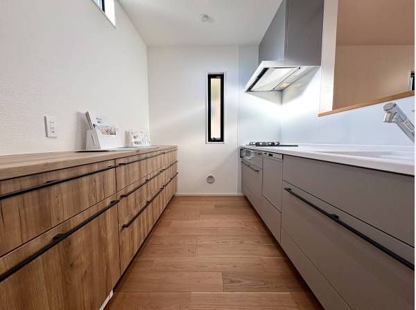 木目の収納と落ち着いた色味が心地よく馴染むキッチンスペース