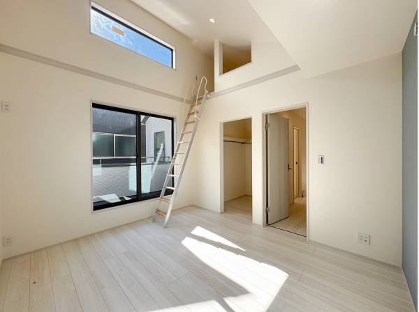 ロフトへと繋がる吹抜けが開放的な約7帖の主寝室