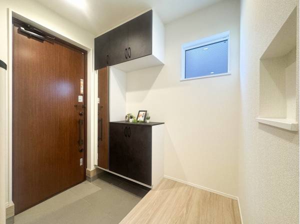 窓から木漏れ日が射し込む優しい印象の玄関スペース