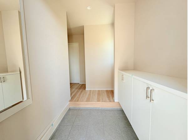 身だしなみ確認に便利な姿見付き。白を基調とした、ご家族を明るく迎える玄関