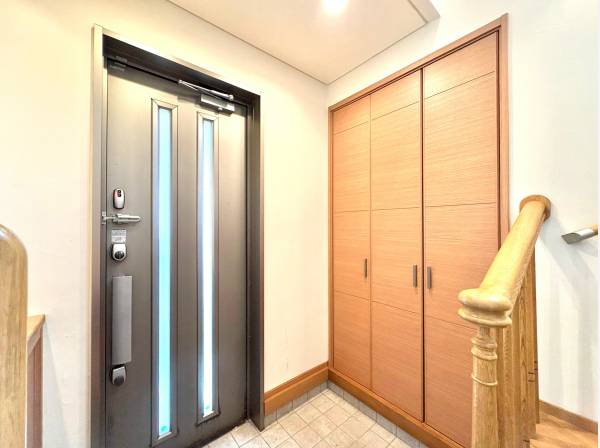 大型収納を備えた、木の温もりが広がる玄関。